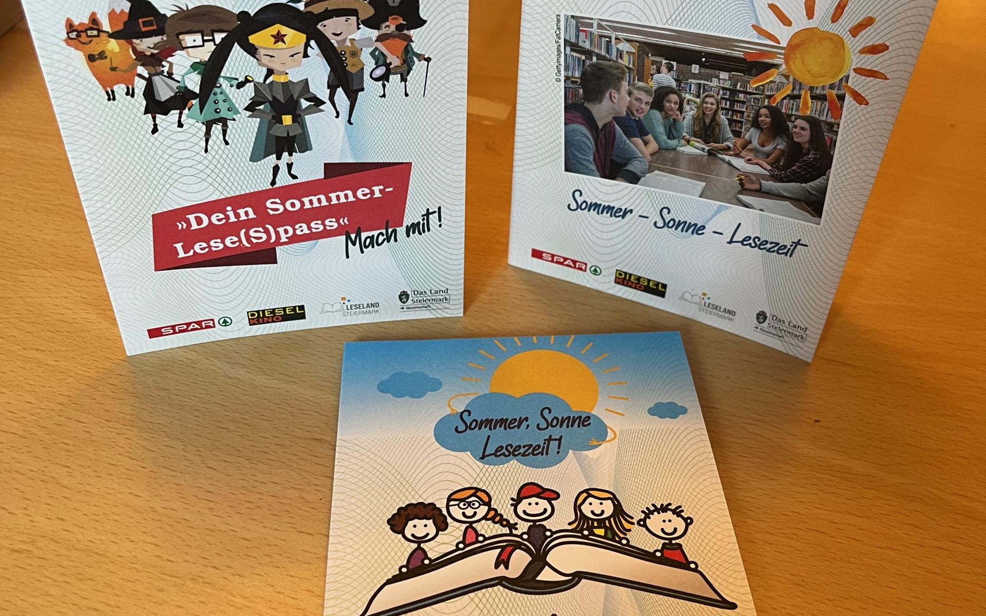 3 Lesepässe liegen auf einem braunen Tisch