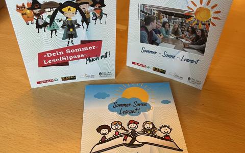 3 Lesepässe liegen auf einem braunen Tisch